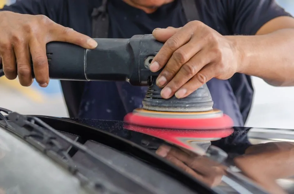detailer machine polishing the side of a boat hull to remove oxidation