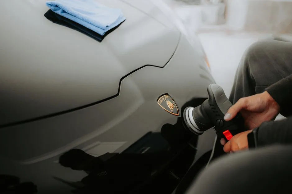 detailer machine cut and polishing a car bonnet during ceramic coating prep