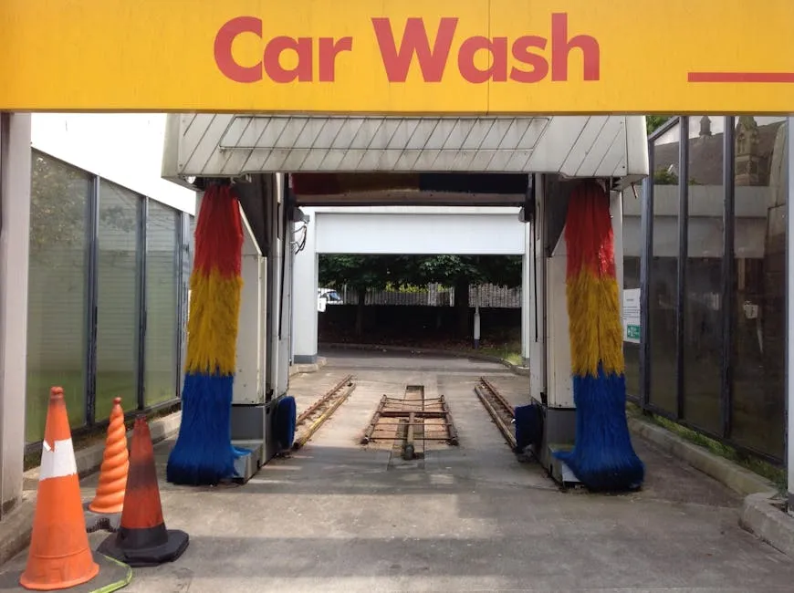 automatic drive-through car wash brushes spinning against a car